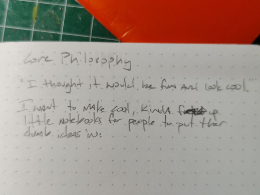Imageof a notebook with "Core Philosophy - I thought it would be fun and look cool - I want to make cool, kinda fucked up little notebooks for people to put their dumb ideas in"